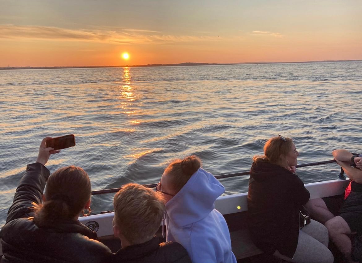 lovely view of the sunset from boat with passengers in foreground